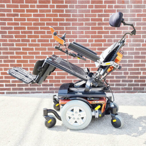 Pride Quantum 6 Edge Power Chair in orange - left side view with seat tilted back